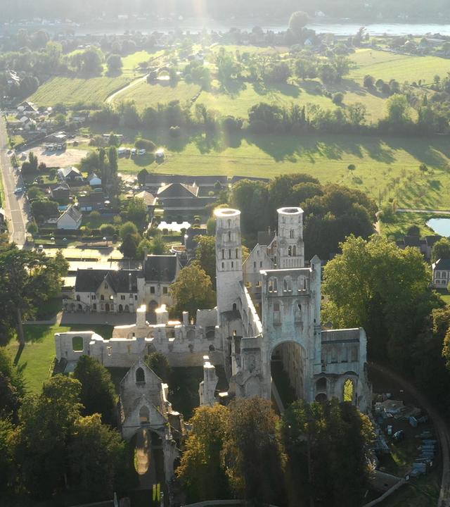 "Die Normandie - Frankreichs grüner Norden": Abtei in dörflicher Landschaft.