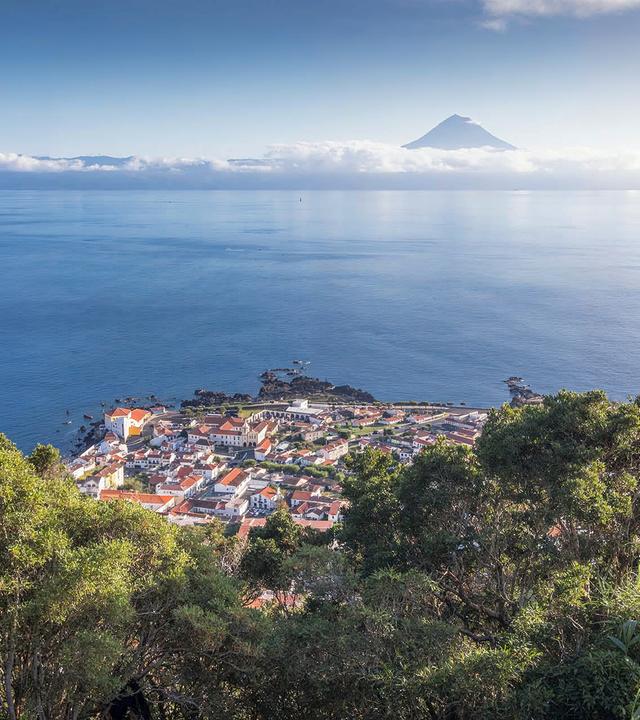"Traumorte - Azoren": Grüne Landschaft und Blick über das Meer auf eine Vulkanspitze.
