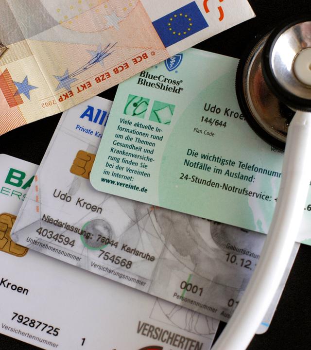 Stethoskop, Krankenkassenkarten und Geldschein - Ersatzkasse, private Krankenversicherung oder doch bei der gesetzlichen bleiben?, Objekte; 2004, Symbolfoto, Gesundheitswesen, Krankenkassenkarte, Versichertenkarte, Versichertenkarten, Krankenkasse, Krankenkassen, Krankenversicherungen, Chipkarte, Chipkarten, Versicherungskarte, Versicherungskarten, Karte, Karten, privat krankenversichert, Ersatzkassen, Barmer, Allianz, Gesundheitsreform, Gesundheitsreformen, Sozialreform, Sozialreformen, Praxisgebühr, Zuzahlung, Zuzahlungen, Geld, Geldscheine, 50 Euro, Euroschein, Euroscheine, fünfzig, Eigenanteil, Gebühr, Gebühren, Praxisgebühren, Beteiligung, Kosten, Gesundheitskosten; , quer, Kbdig, Gruppenbild, close, Versicherungen, Wirtschaft, Deutschland, , Gesundheit