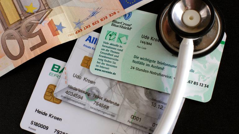Stethoskop, Krankenkassenkarten und Geldschein - Ersatzkasse, private Krankenversicherung oder doch bei der gesetzlichen bleiben?, Objekte; 2004, Symbolfoto, Gesundheitswesen, Krankenkassenkarte, Versichertenkarte, Versichertenkarten, Krankenkasse, Krankenkassen, Krankenversicherungen, Chipkarte, Chipkarten, Versicherungskarte, Versicherungskarten, Karte, Karten, privat krankenversichert, Ersatzkassen, Barmer, Allianz, Gesundheitsreform, Gesundheitsreformen, Sozialreform, Sozialreformen, Praxisgebühr, Zuzahlung, Zuzahlungen, Geld, Geldscheine, 50 Euro, Euroschein, Euroscheine, fünfzig, Eigenanteil, Gebühr, Gebühren, Praxisgebühren, Beteiligung, Kosten, Gesundheitskosten; , quer, Kbdig, Gruppenbild, close, Versicherungen, Wirtschaft, Deutschland, , Gesundheit