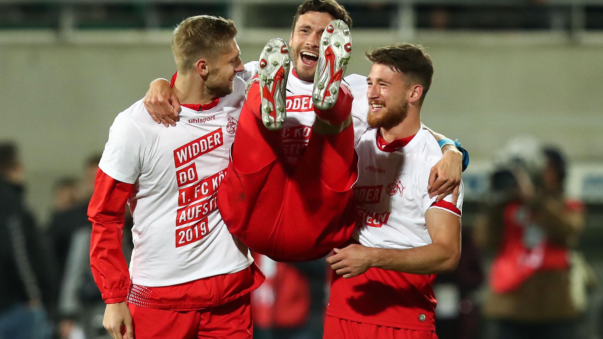 Spieler des 1. FC Köln jubeln in Tshirts mit der Aufschrift "Widder Do" nach Aufstieg 2019