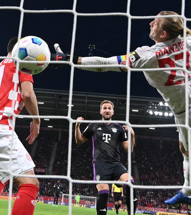 Münchens Harry Kane (M) erzielt das Tor zum 2:0 gegen den Mainzer Torwart Robin Zentner (r).