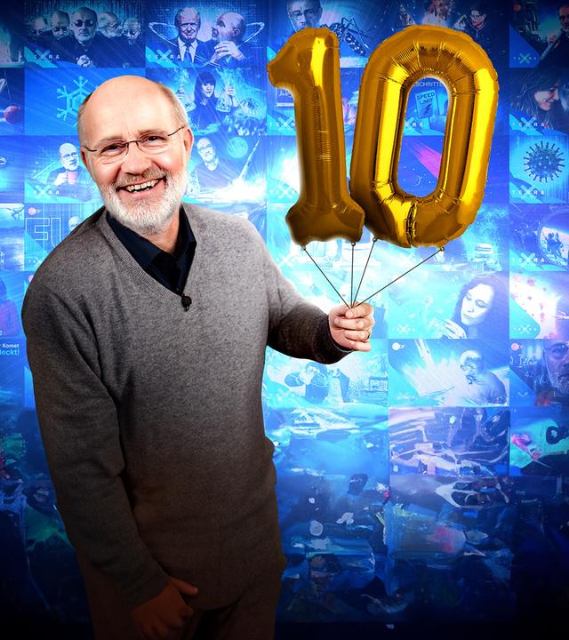 Harald Lesch mit einer 10 aus Luftballons.