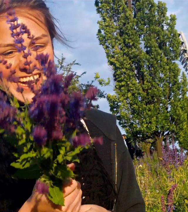 Eine lachende Frau mit einem Blumenstrauß in den Händen