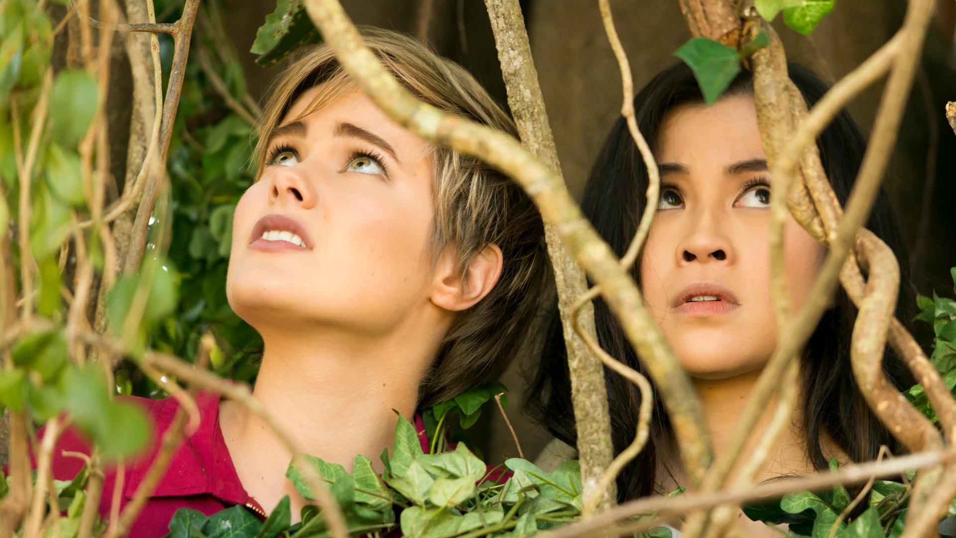 Imogen und Kyra sitzen in einem Gebüsch.