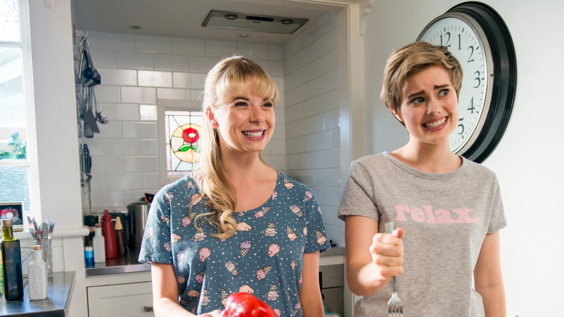 Lily und Imogen sind in Kyras Küche mit an Gabeln aufgespießten Paprikas.