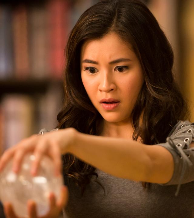 Kyra berührt mit ihrem ausgestreckten Arm und mit einem erstaunten Gesichtsausdruck eine Kugel.