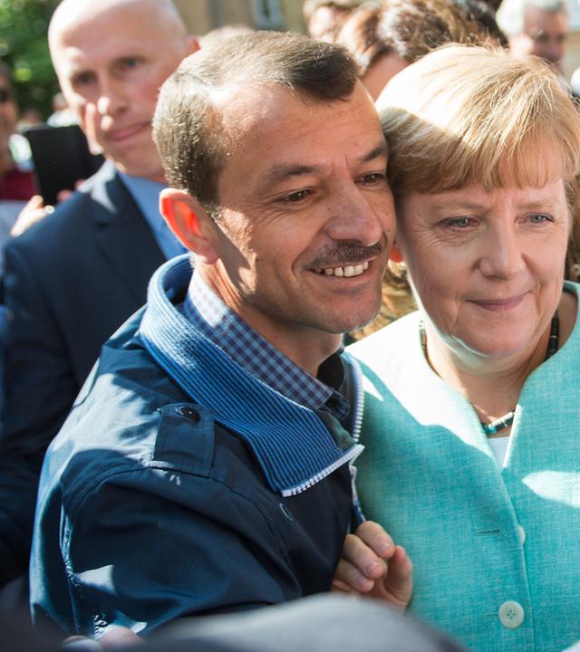 Merkel macht ein Selfie mit einem Flüchtling