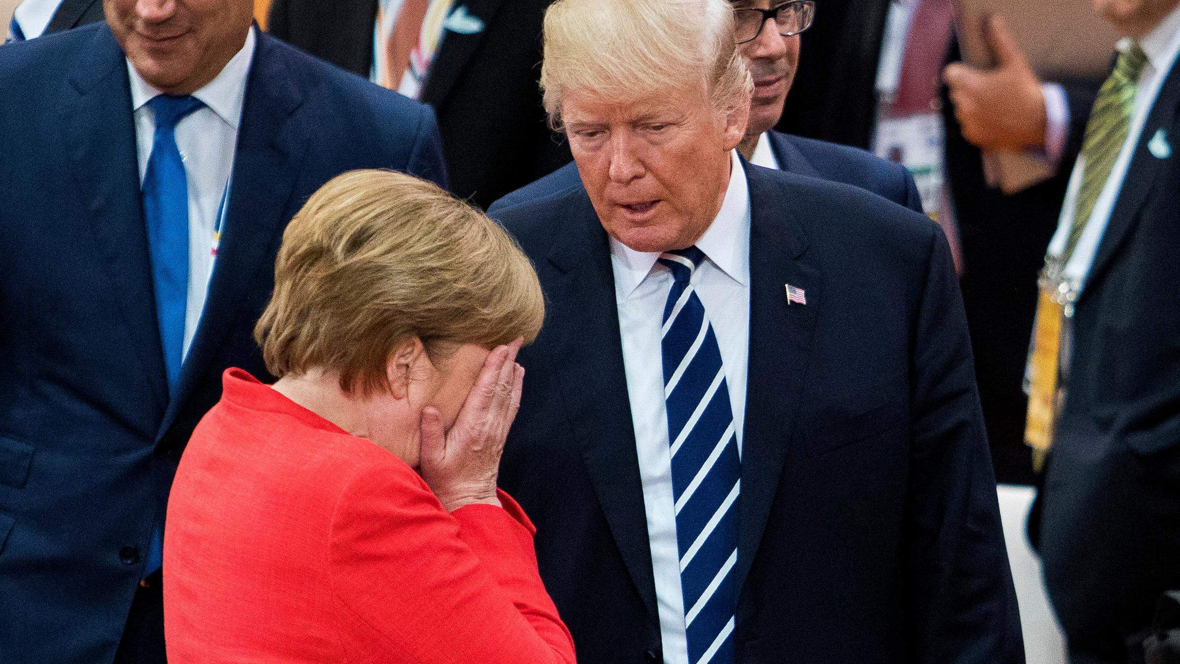 Das Bild zeigt Angela Merkel wie sie im Gespräch mit Donald Trump die Hände vorm Gesicht verschließt.