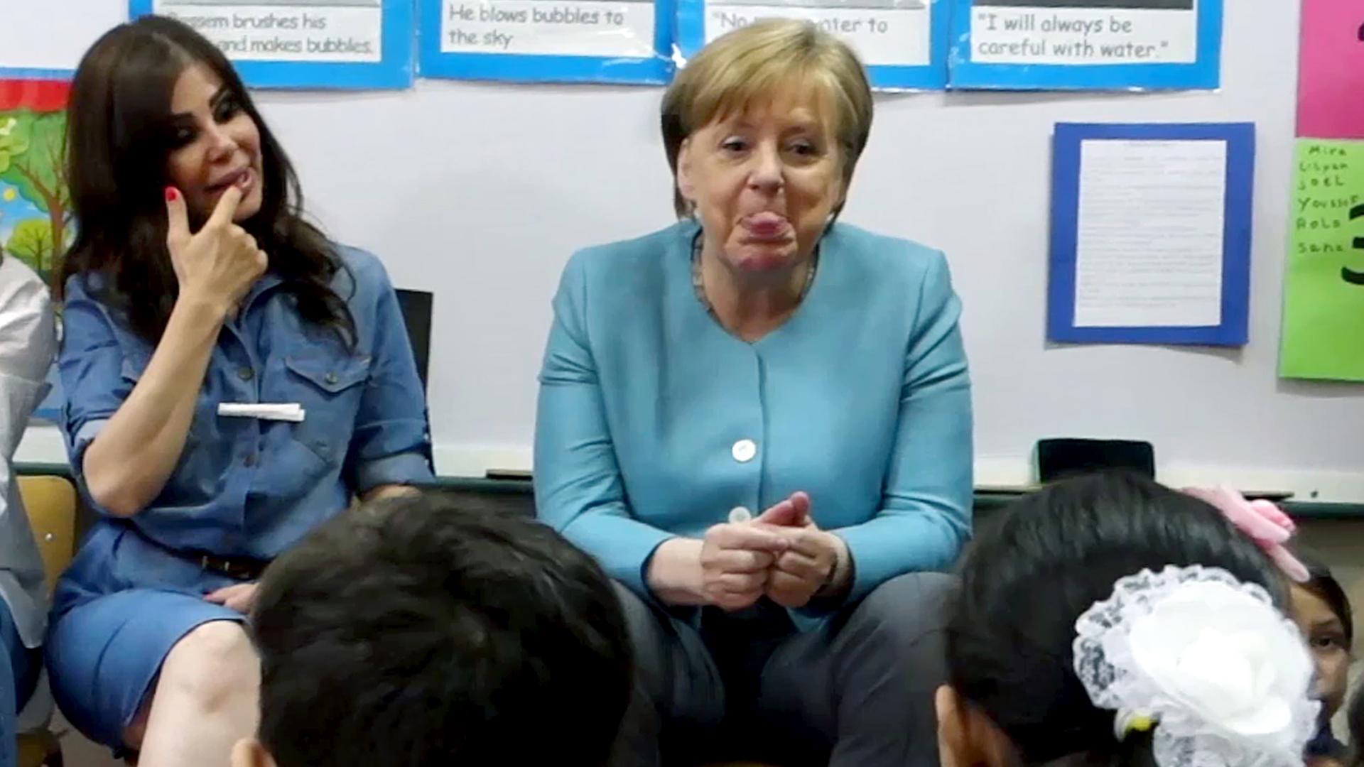 Das Bild zeigt Angela Merkel wie sie die Zunge herausstreckt.