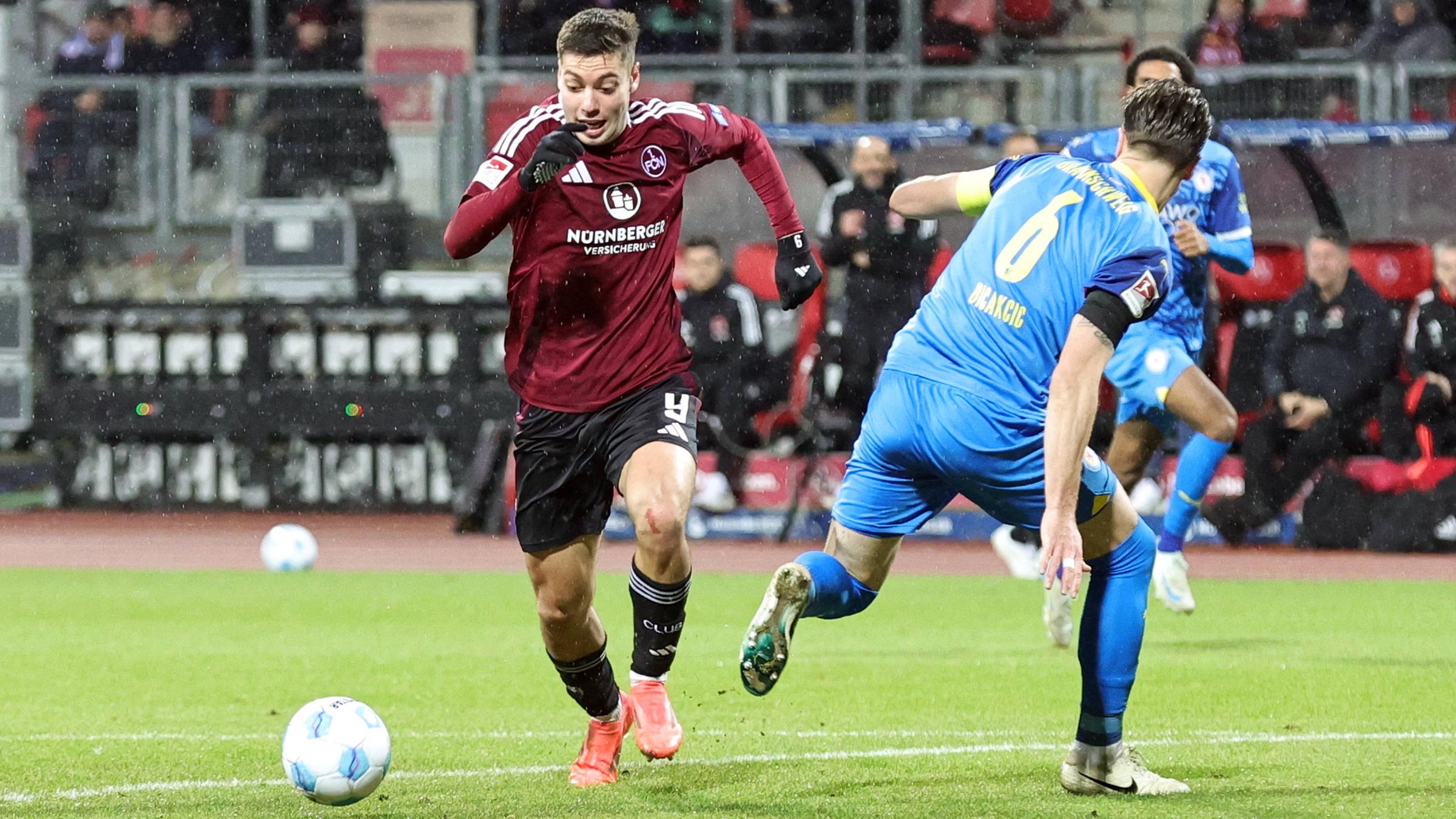 Nürnbergs Stefanos Tzimas und Ermin Bicakcic von Eintracht Braunschweig kämpfen um den Ball.