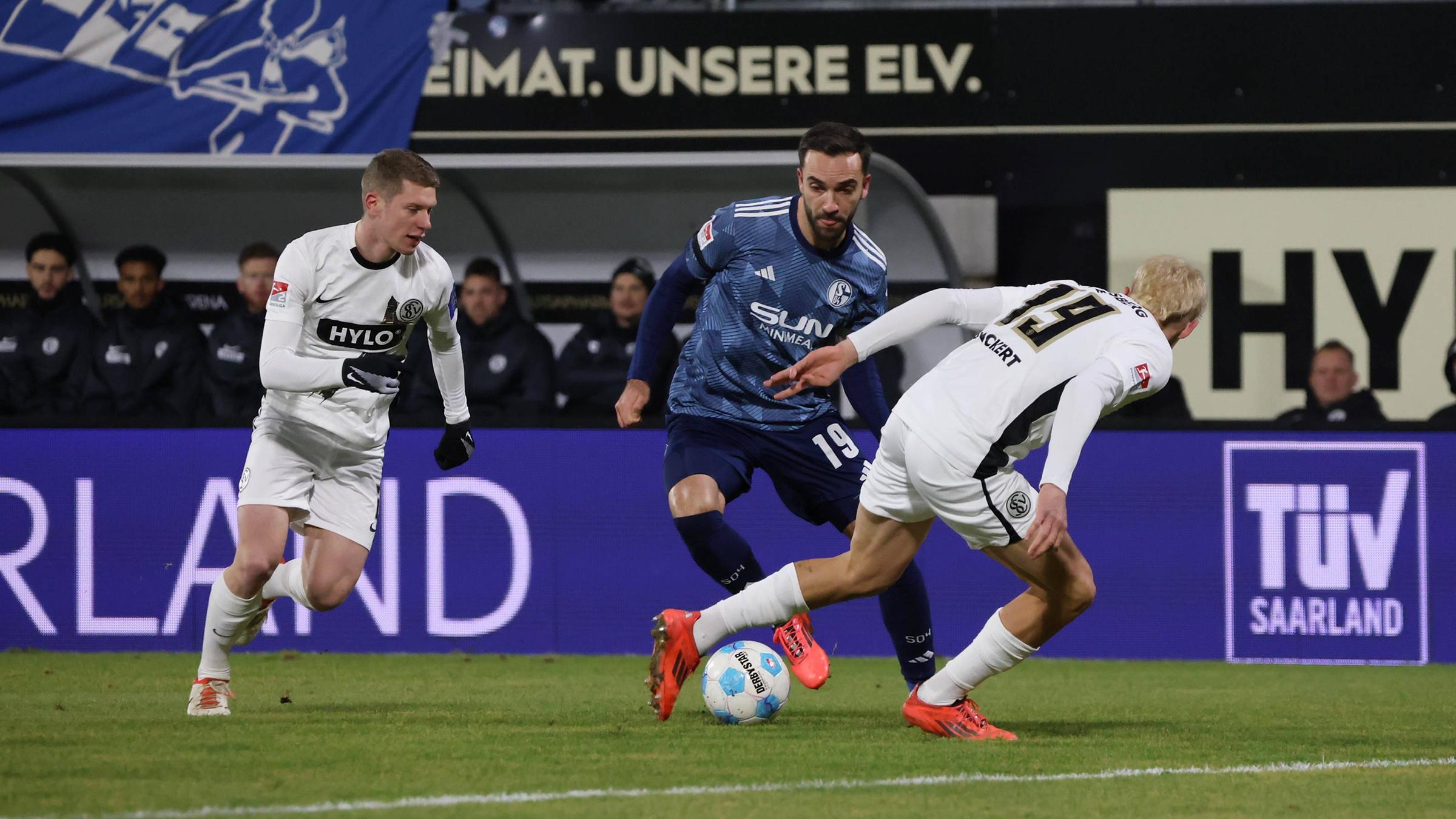 Schalkes Kenan Karamankämpft um den Ball gegen Lukas Pinckert und Elias Baum vom SV Elversberg.