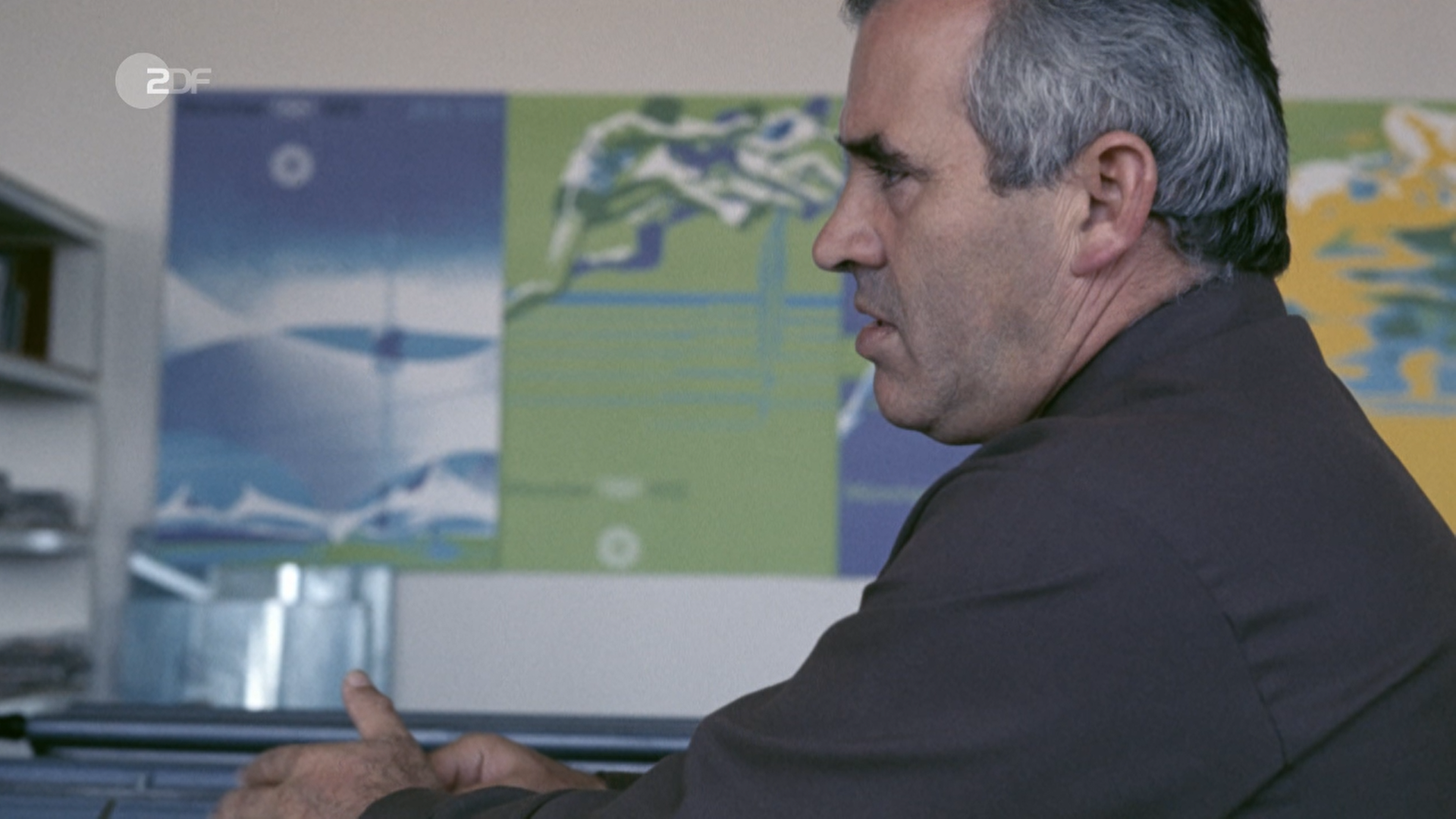 Ein Bild im Profil von Ottl Eicher, im Hintergrund einige seiner Werke