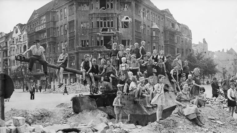 Kinder spielen im Jahr 1945 im durch Bomben zerstörten Berlin auf einem Panzer.