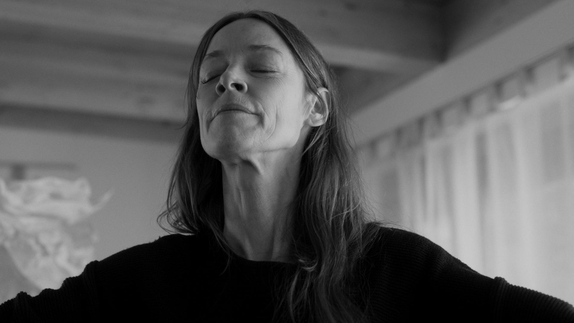 "Im Haus meiner Eltern": Holle (Jenny Schily) hat unter Anspannung ihre Arme ausbreitet, die Augen geschlossen und atmet tief durch.