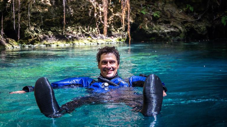 "Terra X: Faszination Wasser - Höhlen": Uli Kunz treibt in Rückenlage auf dem Wasser und schaut lächelnd in die Kamera.