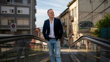 "Am Puls mit Christian Sievers - Wie retten wir unsere Städte? – Leben statt Leere": Christian Sievers steht auf einer Rolltreppe in der Innenstadt von Santander und schaut zur Seite.
