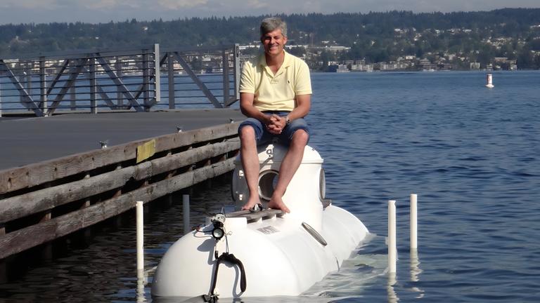 "Terra X: "Titan" - Todesfahrt zur Titanic":  Stockton Rush, der Erbauer der Titan sitzt auf seinem U-Boot, das über Wasser an einem Steg festliegt.