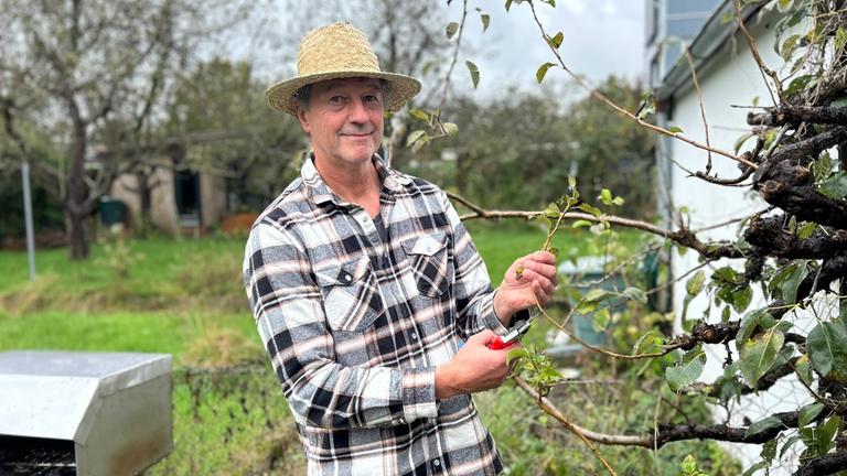 "ZDF.reportage: Arbeiten - Lohnt sich das?": Michael schneidet Rosen im Garten.