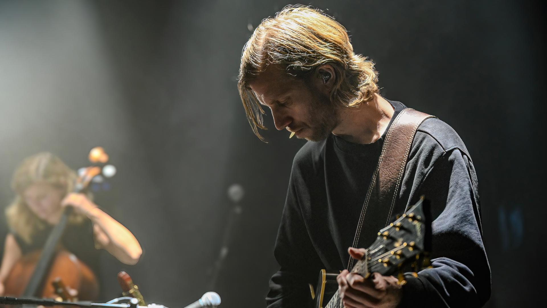 "Terra X: Musik - Große Gefühle": Ferdinand Kirner steht im Vordergrund und spielt Gitarre. Ella Rohwer sitzt seitlich dahinter und spielt Cello.