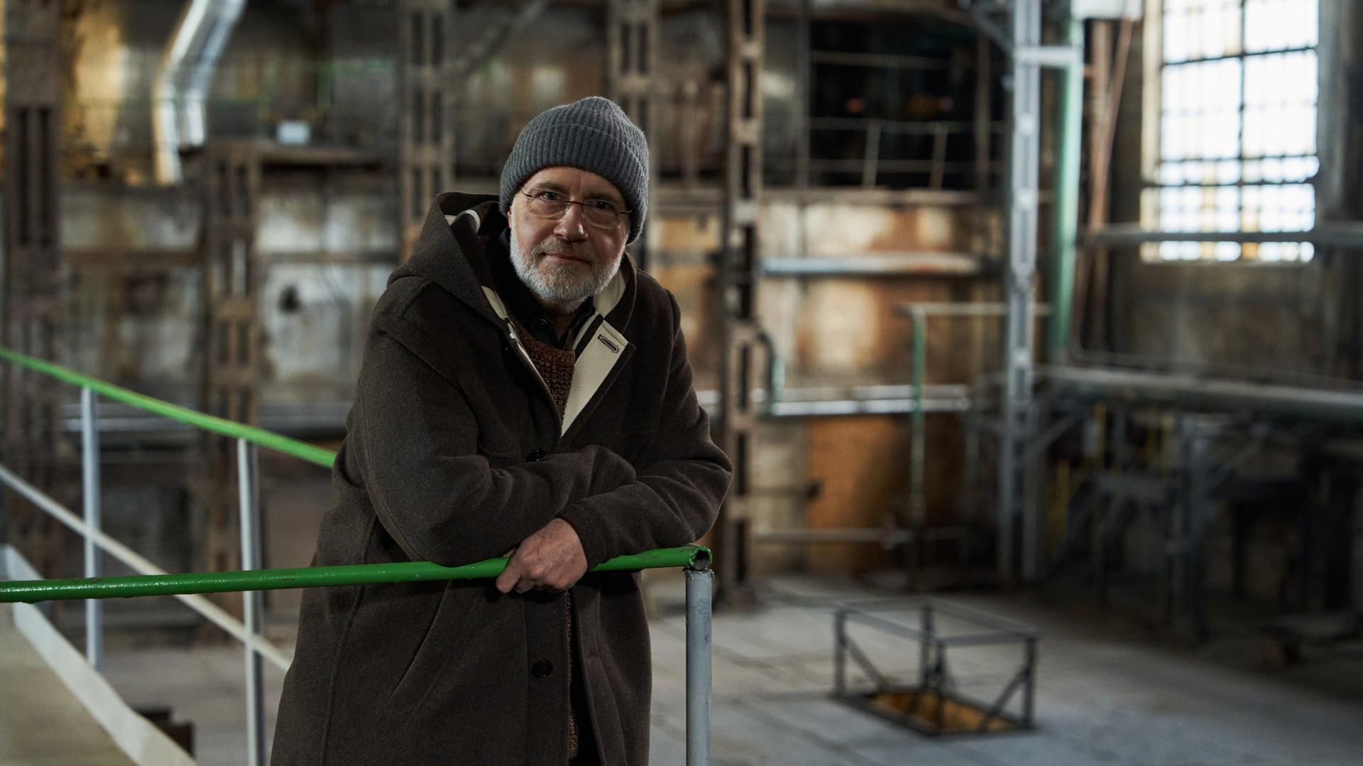 "Terra X - Die großen Fragen: Haben wir eine Seele?": Harald steht an einer Brüstung in einer alten Fabrikhalle.