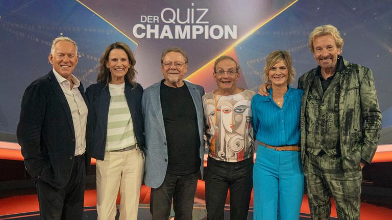 "Der Quiz-Champion": Johannes B. Kerner, Katrin Müller-Hohenstein, Jürgen von der Lippe, Wigald Boning, Barbara Hahlweg und Thomas Gottschalk im Studio vor dem Logo des "Quiz-Champion".