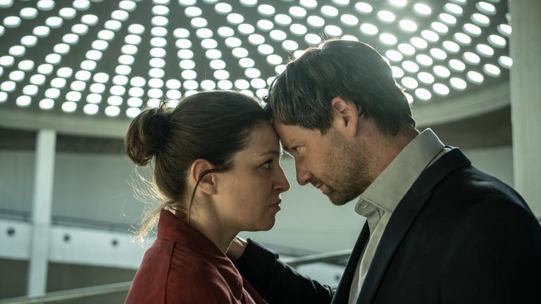 "Katharina Tempel - Was wir begehren": Katharina Tempel (Franziska Hartmann) und Volker Tempel (Florian Stetter) stehen sich Kopf an Kopf gegenüber und schauen sich an.