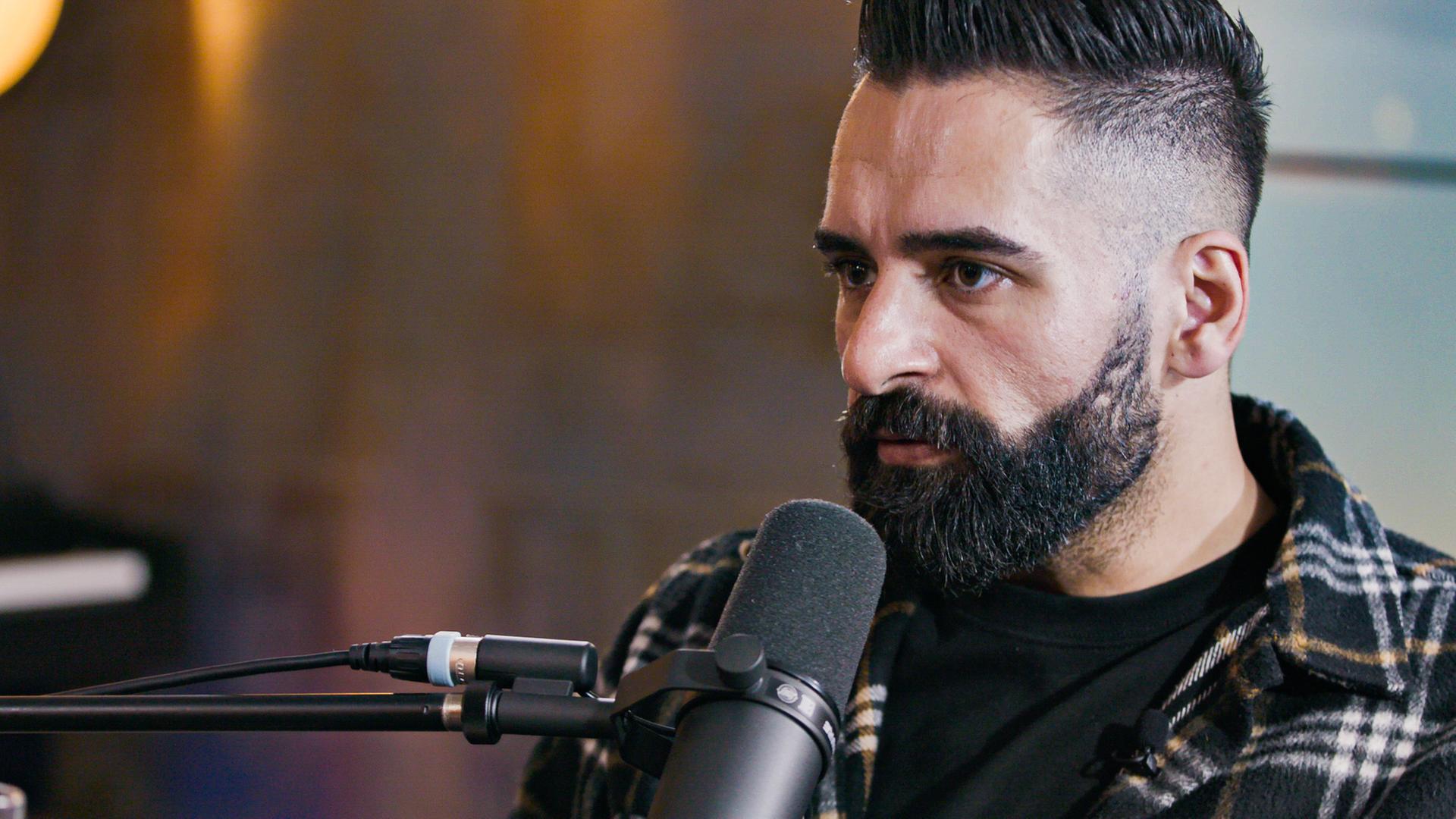 "plan b: Re:turn - Schweigen brechen, Leben retten": Nahaufnahme: Said Ibrahim steht am Mikrofon.