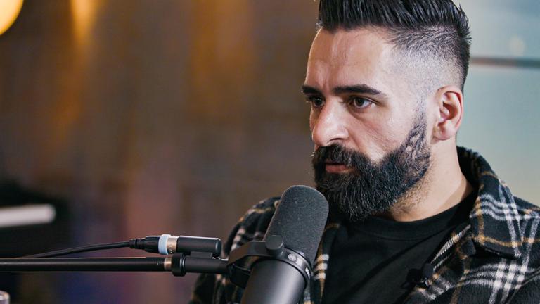 "plan b: Re:turn - Schweigen brechen, Leben retten": Nahaufnahme: Said Ibrahim steht am Mikrofon.