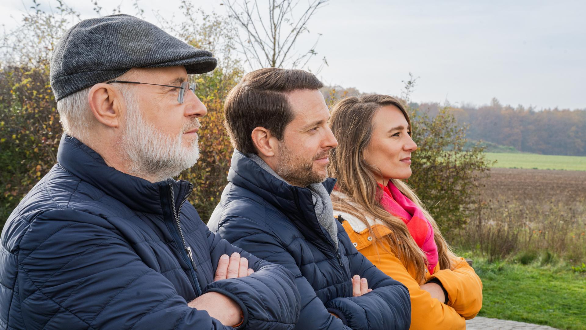 "Der große Terra X-Jahresrückblick 2025":  Harald Lesch, Mirko Drotschmann und Jasmina Neudecker stehen im Profil seitlich nebeneinander. Alle drei haben ihre Arme übereinandergeschlagen.
