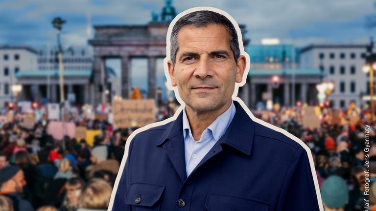 "Am Puls mit Mitri Sirin - Ist unsere Meinungsfreiheit in Gefahr?": Montage: Ein Porträtfoto von Mitri Sirin liegt vor einer Aufnahme des Brandenburger Tors, an dem eine Demonstration stattfindet.