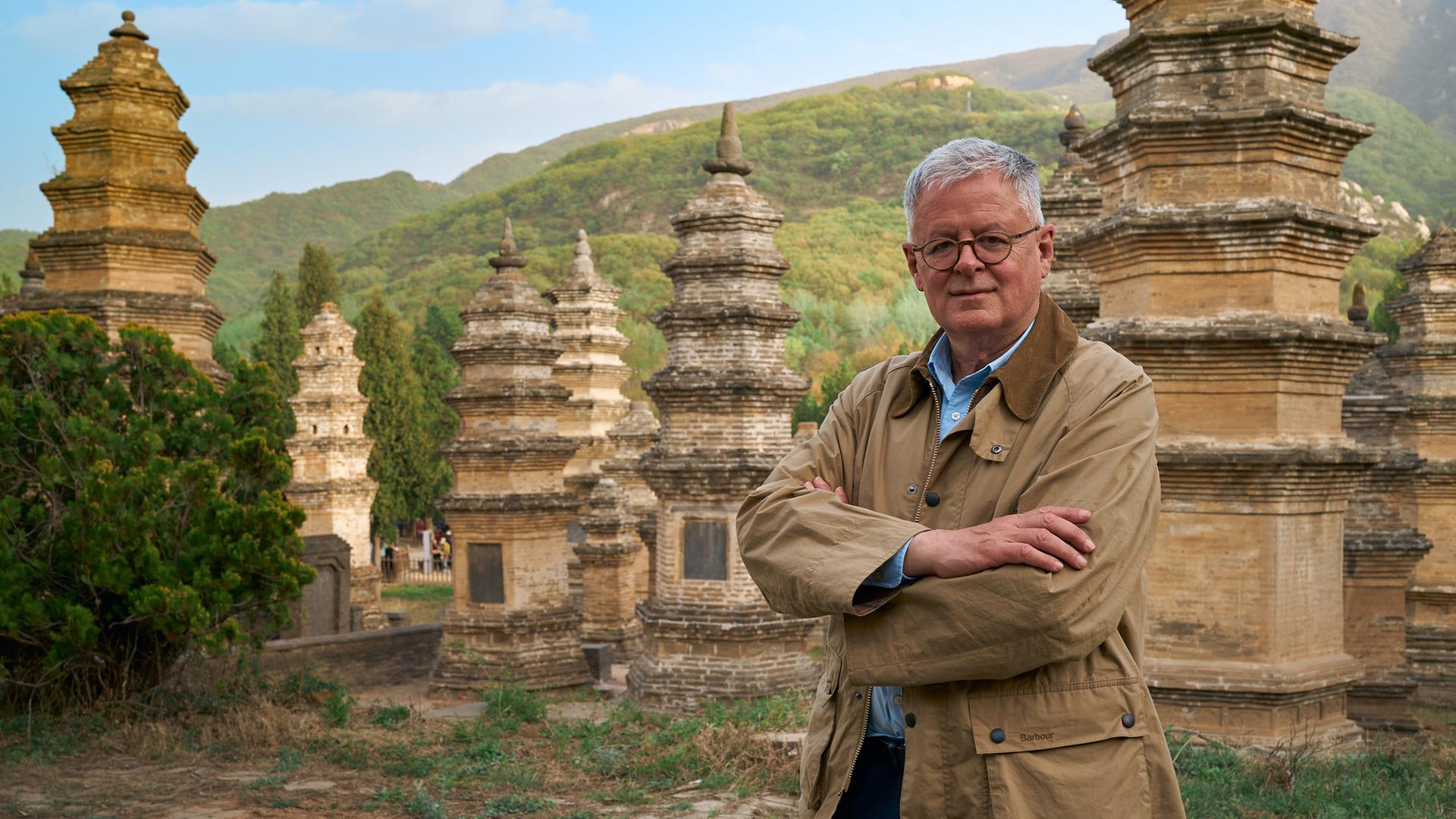 "Welten-Saga: Die Schätze Chinas": Moderator Christopher Clark steht mitten im Pagodenwald in der Nähe des Shaolin-