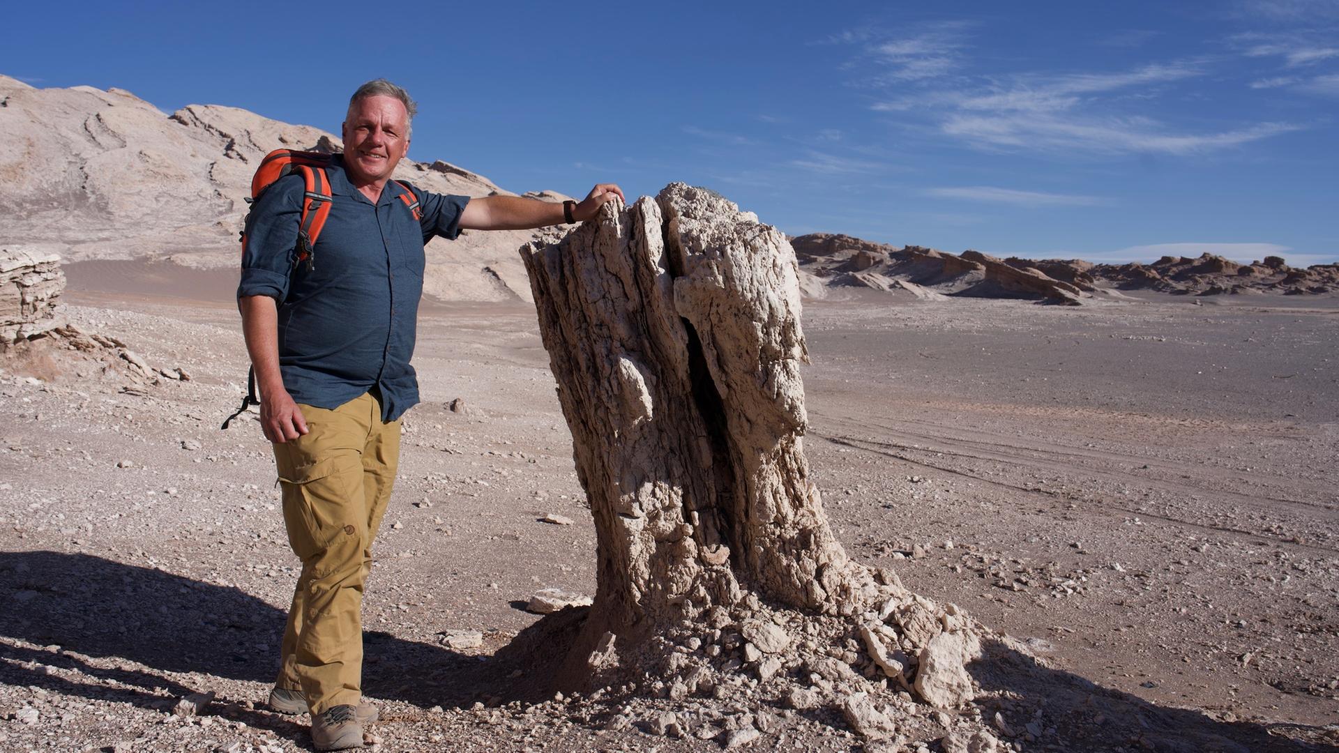 "Expedition Anden - Gebirge in Bewegung": Colin Devey lehnt an einem Stein in einer wüstenartigen Landschaft.