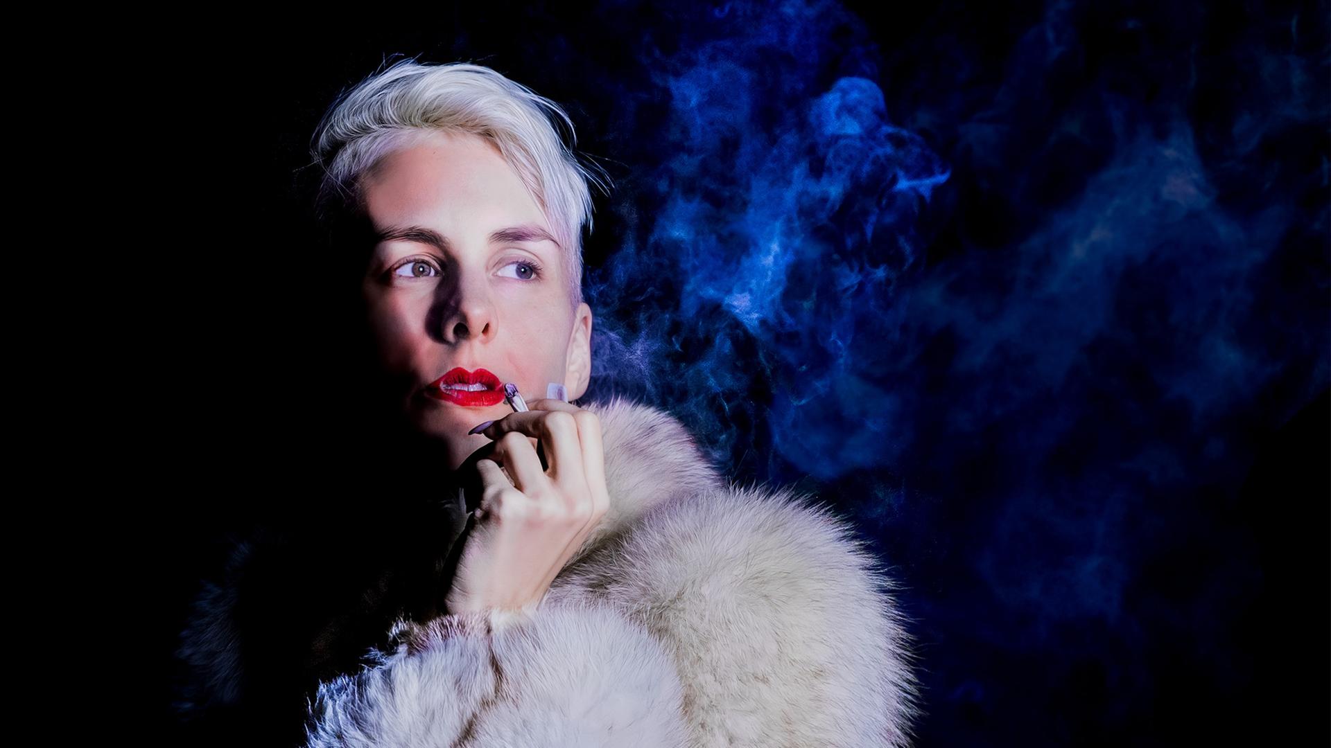 "Lisa Eckhart: Kaiserin Stasi":  Lisa Eckhart trägt einen Pelzmantel und raucht eine Zigarette.