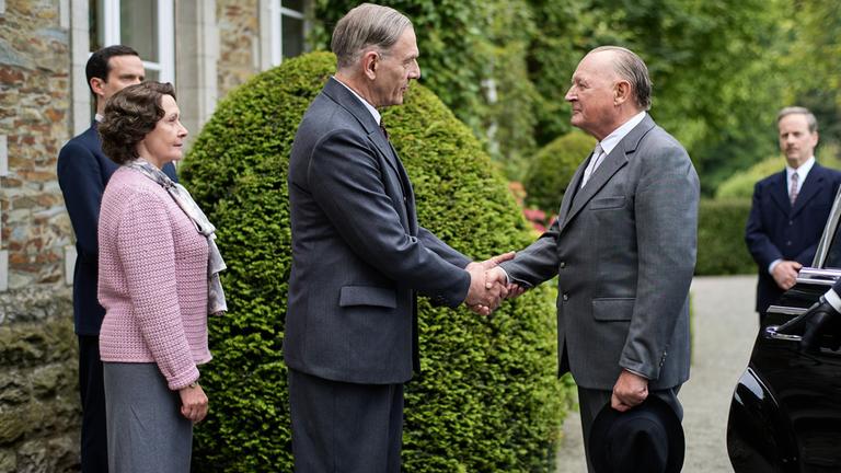 "An einem Tag im September": Charles de Gaulle (Jean-Yves Berteloot) und Konrad Adenauer (Burghart Klaußner) stehen sich vor dem Landhaus gegenüber und begrüßen sich mit einem Handschlag. Hinter de Gaulle stehen seine Frau Yvonne (Hélène Alexandridis) und sein Sohn Philippe (Pierre Lognay) und beobachten das Ganze. Günther Bachmann (Fabian Busch) steht etwas abseits hinter Adenauer und sieht ebenfalls zu.