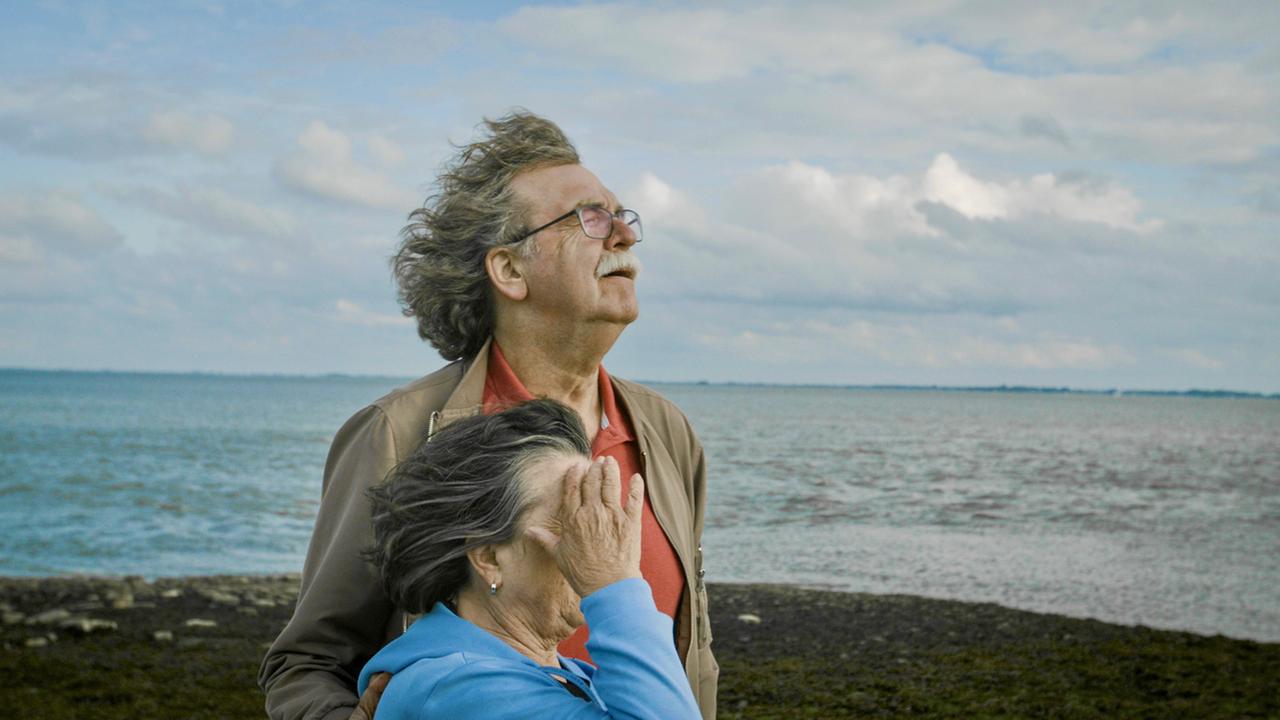 "Jenseits von Schuld": Ulla und Didi Högel stehen nebeneinander mit den Gesichtern dem Wind zugewandt am Strand.