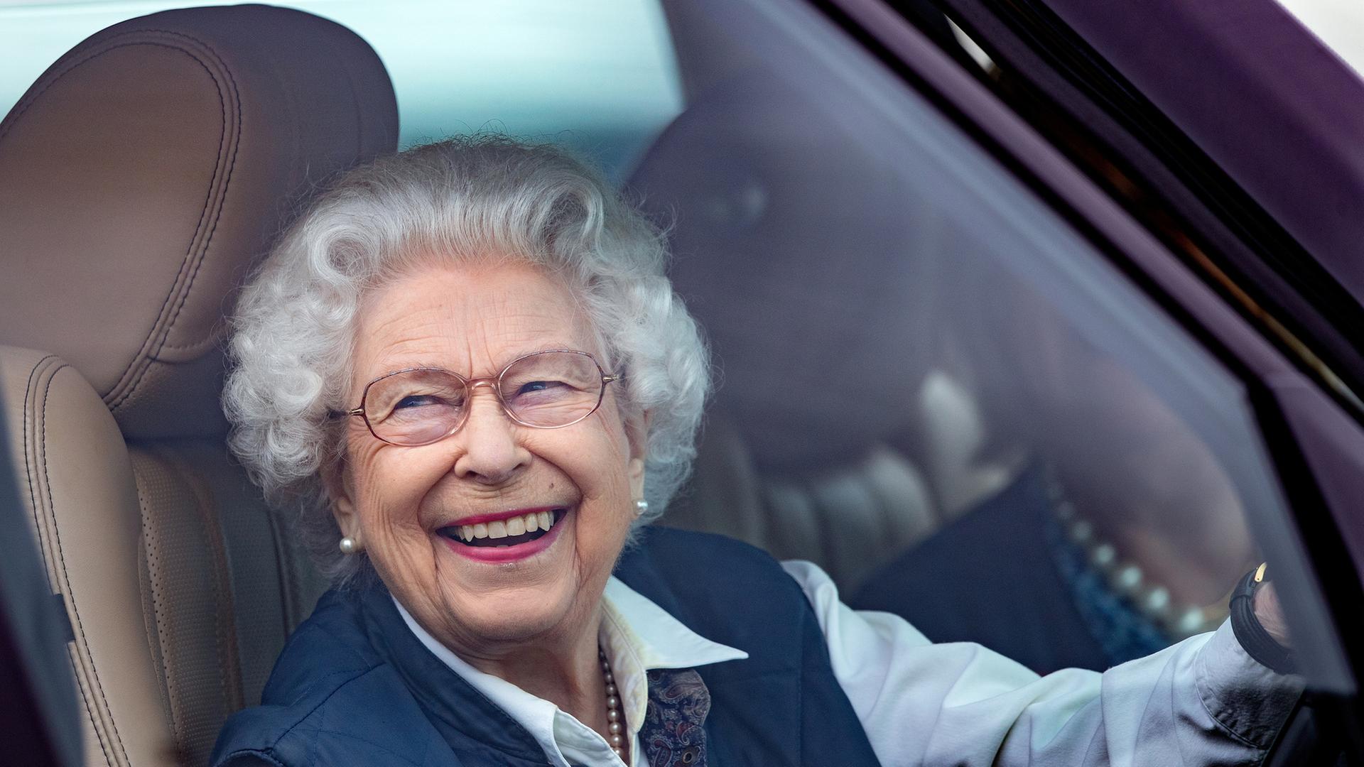 "Terra X History: Die Queen und ich": Queen Elizabeth II. fährt in ihrem Range Rover in Windsor im Sommer 2021. Sie schaut lachend aus dem Seitenfenster heraus.