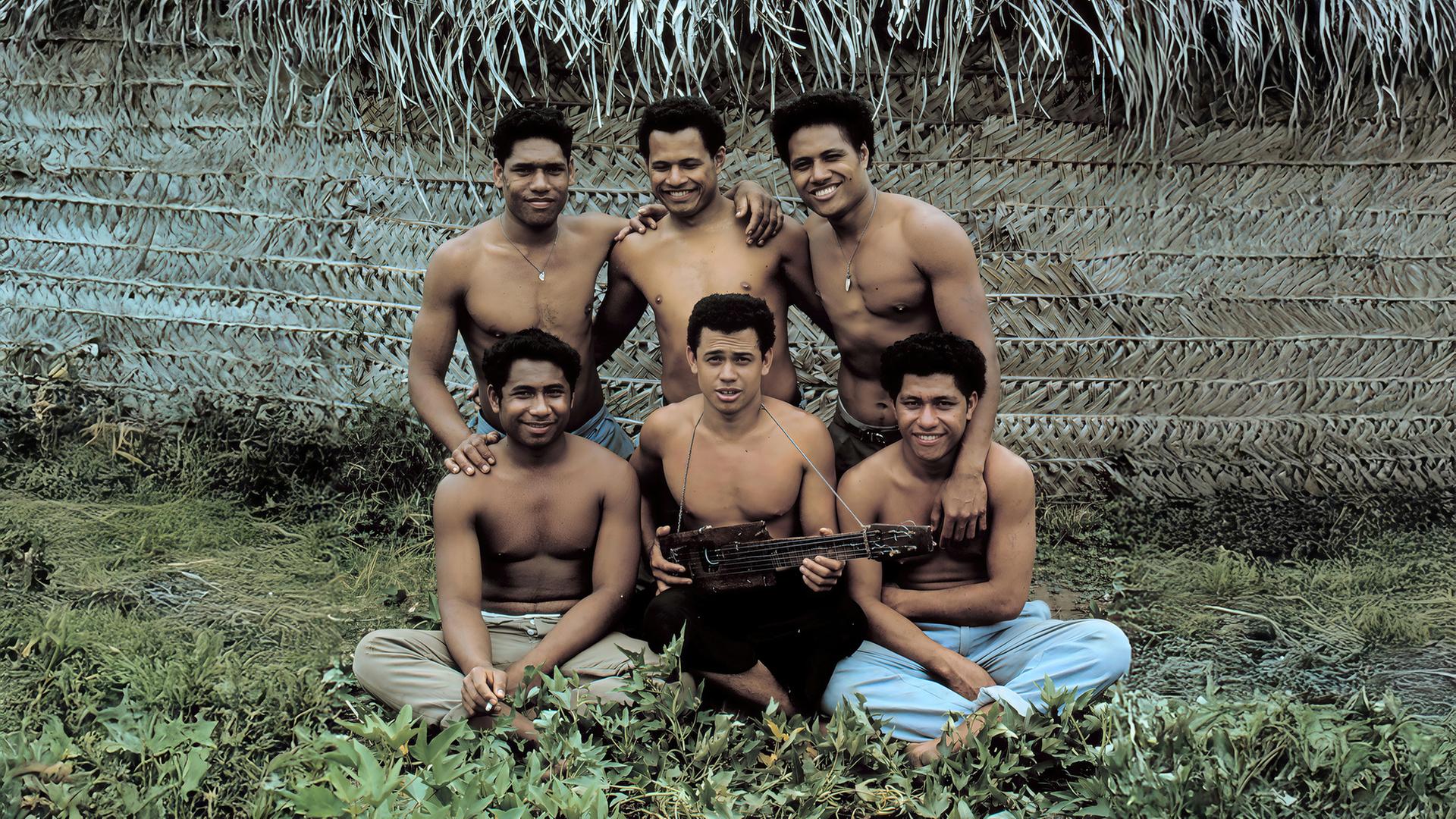 "Terra X: Verschollen": Spielszene: Die sechs "Ata-Boys" sitzen und stehen zusammen vor einer Hütte.