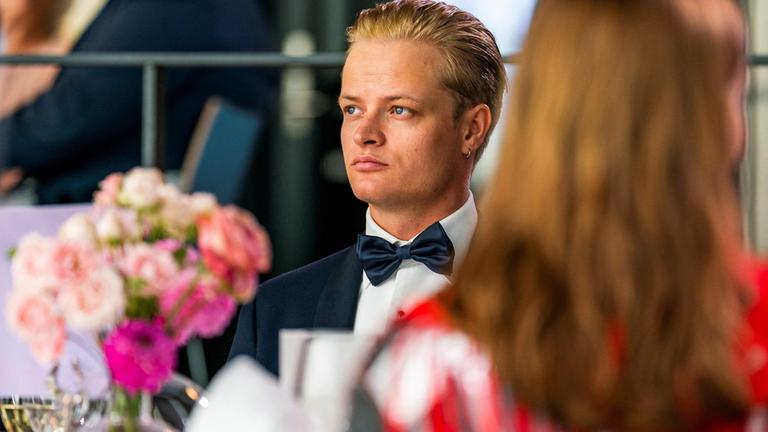 "Im Schatten der Krone - Skandale, Krisen, Jetset": Marius Borg Høiby sitzt bei einem öffentlichem Anlass am Banketttisch.