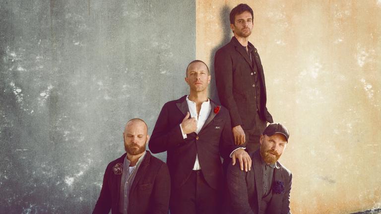"Coldplay: Live in São Paulo": Die vier Bandmitglieder stehen, bzw. sitzen auf unterschiedlichen Höhen an einer Hauswand. Alle sind in Schwarz gekleidet.