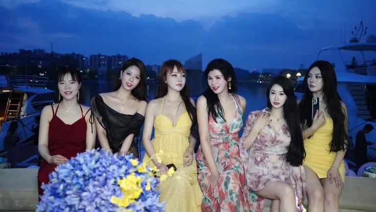  "The Chinese Dream - 24h junges China": Sechs junge Chinesinnen sitzen in der Dämmerung auf einer Yacht und posieren für ein Foto.