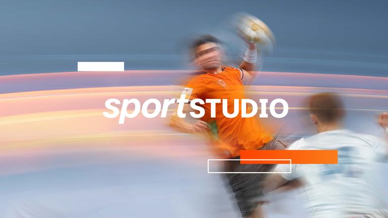 Typical Handball-EM der Männer 2026: Ein Handballer wirft mit dem linken Arm einen orangfarbenen Handball hinter einem Gegenspieler aufs Tor.