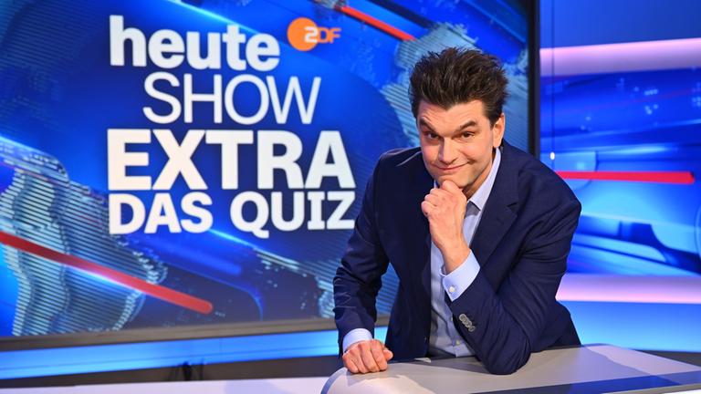 "heute-show extra - Das Quiz": Lutz van der Horst lehnt lässig am Fragepult und lächelt in die Kamera.