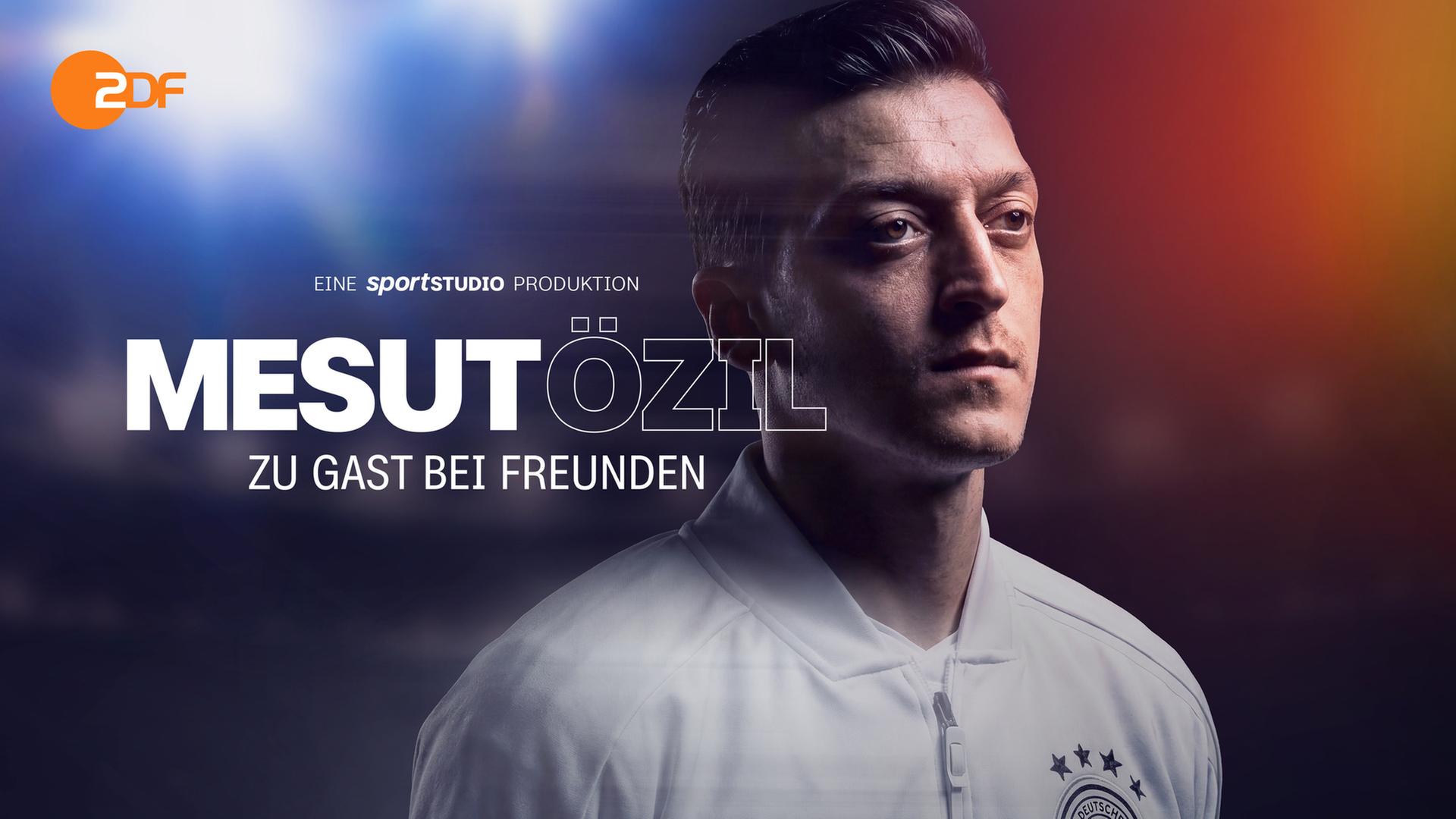"Mesut Özil - zu Gast bei Freunden": Montage: Mesut Özil trägt ein weißes Trikot der deutschen Fußball-Nationalmannschaft und schaut seitlich nach vorne. Er steht vor unscharfem Hintergrund, einem Stadion bei Flutlicht. Darüber liegt in weißer Schrift der Sendungstitel.