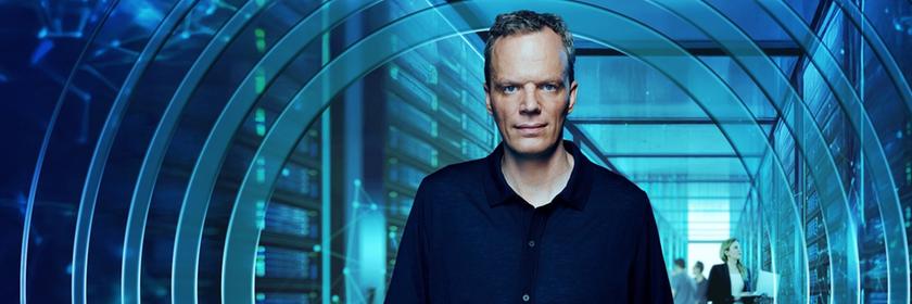  "Am Puls mit Florian Neuhann": Montage: Florian Neuhann steht in einem Flur vor einem graphisch gestalteten Element, einem durchsichtigen Kreis. Hinter ihm im Flur befinden sich drei weitere Personen.