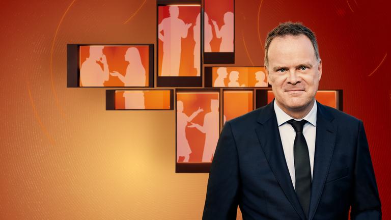 Am Puls - Deutschland diskutiert": Christian Sievers steht vor einer orangefarbenen Wand auf der Icons von stilisierten Menschen abgebildet sind, die sich unterhalten und schaut in die Kamera.