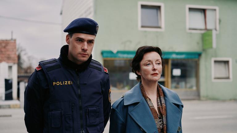 "ACHT - Ein Landkrimi": Patrick Brandl (Thomas Prenn) und Marion Geyer (Regina Fritsch) gehen zusammen die Straße entlang.