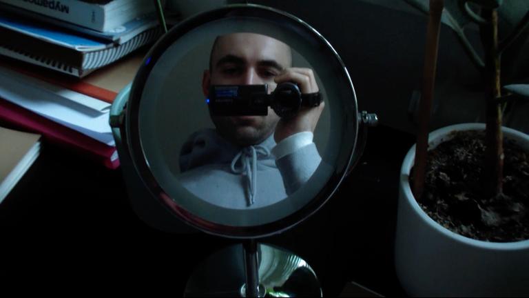 Bildbeschreibung: "Monument": : Junger Mann blickt mit Kamera in Spiegel.