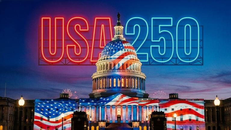 250 Jahre USA: Montage, KI-gestützt: Hinter dem Capitol in Washington bei Nacht mit Feuerwerk liegt die Leuchtschrift "USA 250". Die amerikanische Flagge ist auf das Gebäude projiziert.