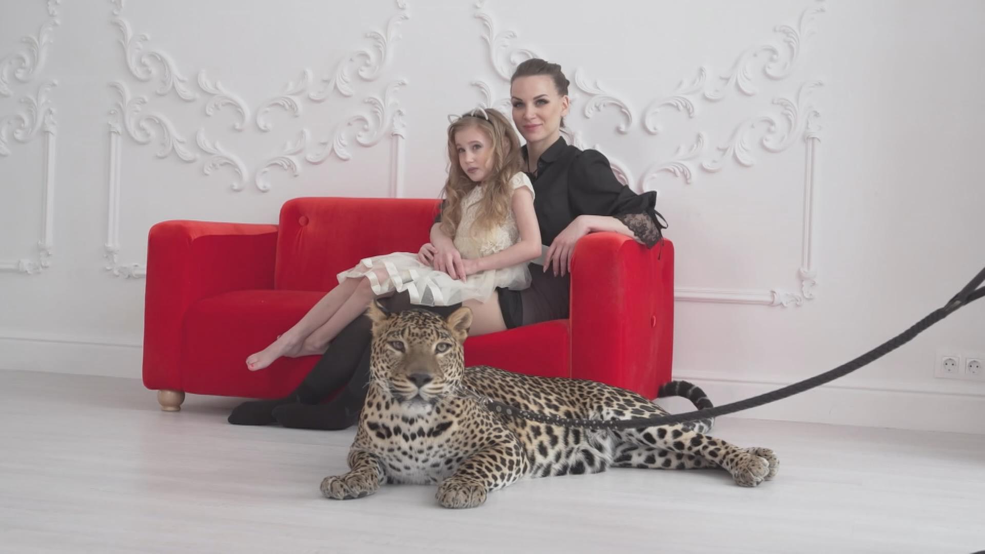 Mutter mit Kind posieren vor Leoparden